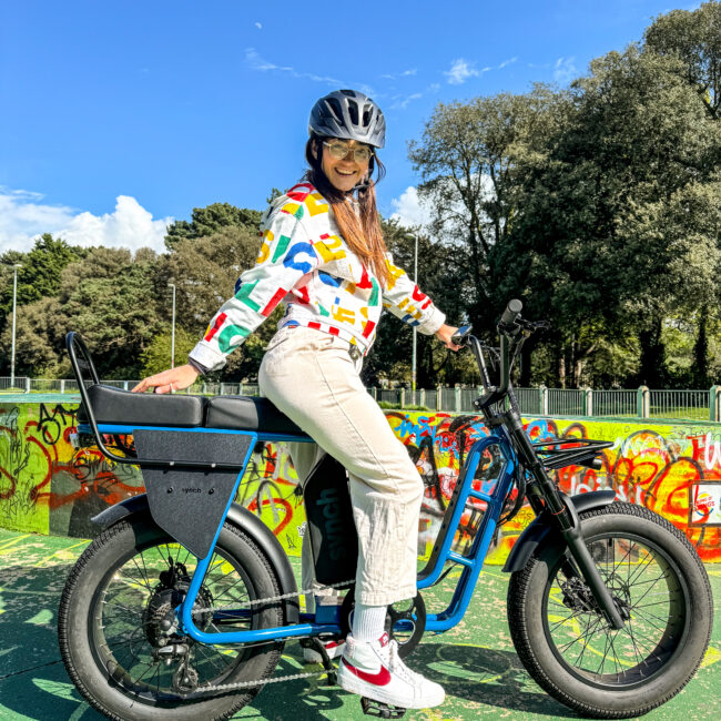 Lady in colourful jumper riding a Longtail ST with extra seat added. 2 seater electric bike